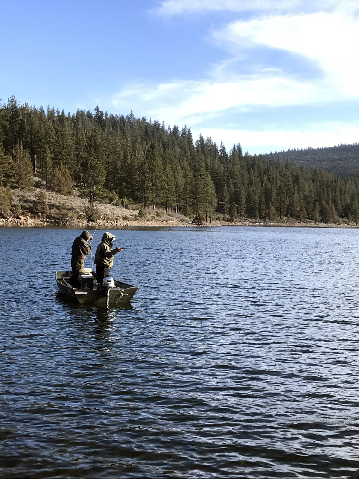 Two fly fisherman fishing from an jon boat